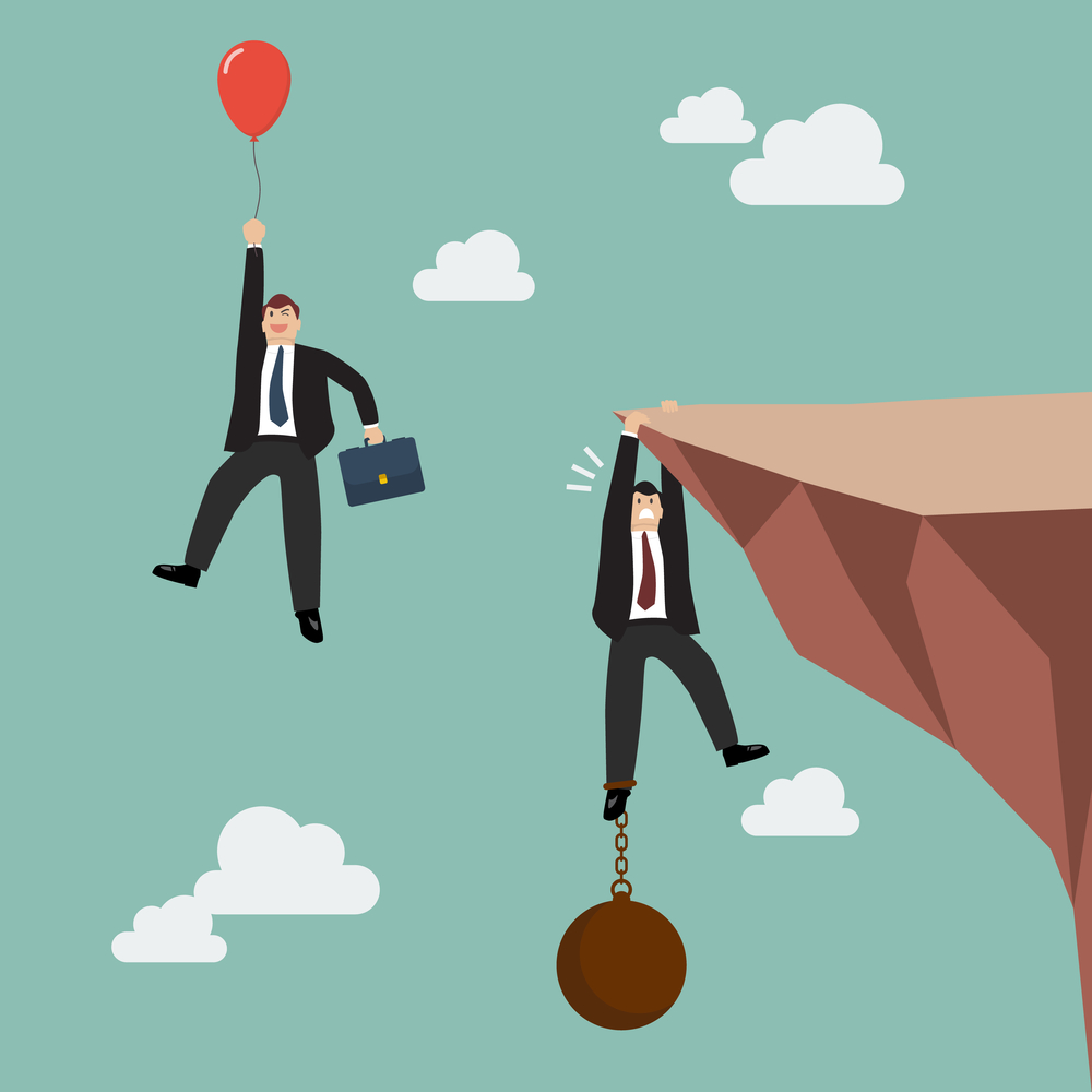 Businessman with red balloon fly pass businessman hold on the cliff with burden. Business competition concept